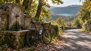 Bicicletta da corsa appoggiata a una fontanella di pietra in una strada nei boschi dei Castelli Romani