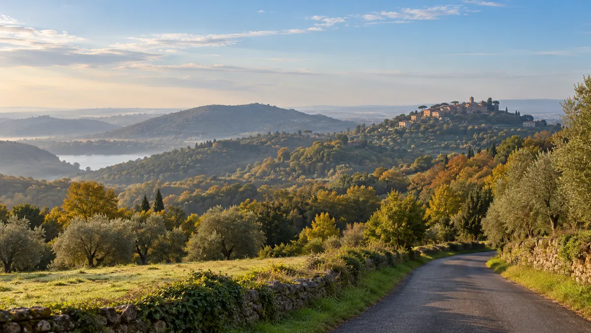 Colline dei Castelli Romani in autunno con strada di campagna e borgo in lontananza
